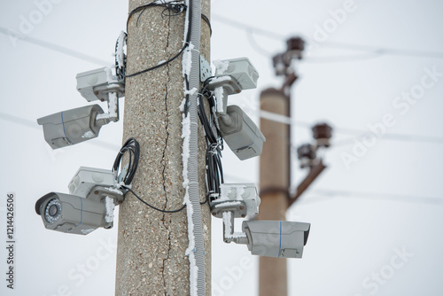 Several snow-covered CCTV cameras on a pole looking in different directions.
