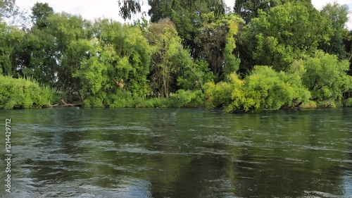 Medium view of the Tumut River with overhanging trees flowing strongly in the Snowy Mountain Region of Australia, New South Wales. photo