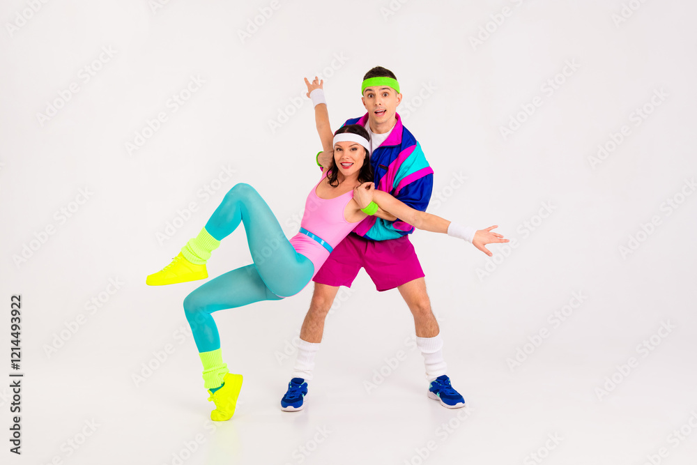 Obraz premium Colorful retro-inspired couple engaging in dynamic partner aerobics against a minimalist white background, embodying vibrant energy