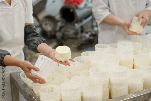 Εκτύπωση καμβά Workers preparing fresh cheese in factory, holding cheese forms and placing them on a table with other forms
