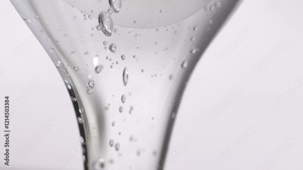 Hyaluronic acid, transparent liquid texture, flowing gel on a light background. Beauty product for skin moisturizing.