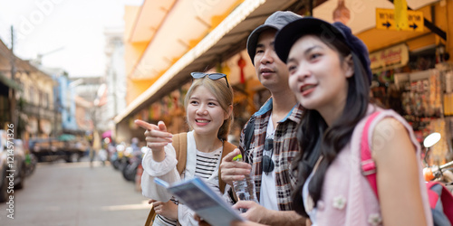 Friends exploring a vibrant market, studying a map while traveling and sharing moments of discovery photo