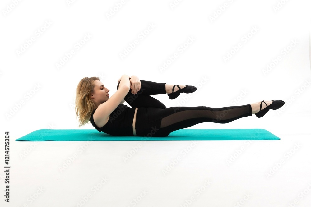 Woman performing a pilates exercise on a teal mat in a bright, minimal studio setting Woman performing a pilates exercise on a teal mat in a bright, minimal studio setting
