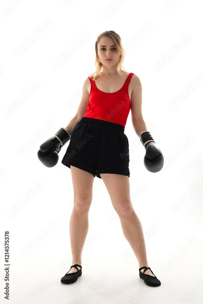 Confident young woman poses in boxing gloves and attire for a striking fitness portrait in a bright studio setting Confident young woman poses in boxing gloves and attire for a striking fitness portrait in a bright studio setting