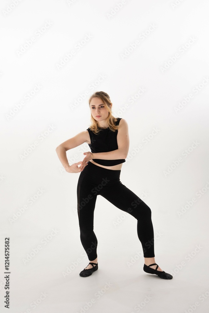 Dynamic dance pose by a young woman in black attire in a minimalist studio setting Dynamic dance pose by a young woman in black attire in a minimalist studio setting