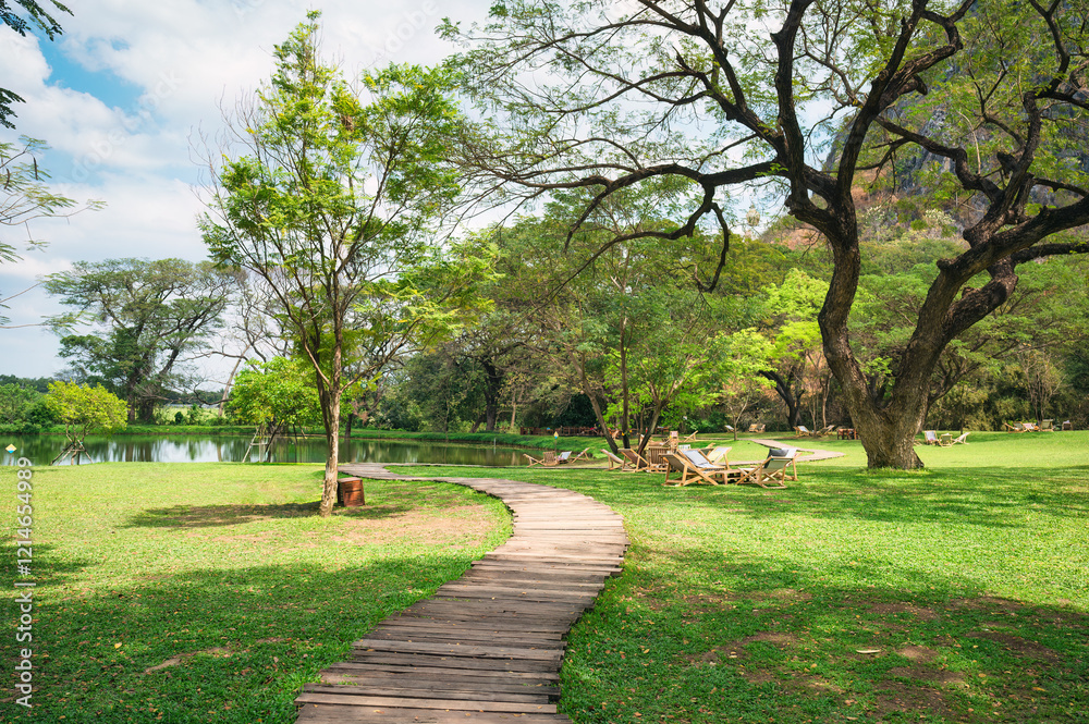 Serene Pathway Through Lush Green Landscape by Tranquil Water Body Serene Pathway Through Lush Green Landscape by Tranquil Water Body