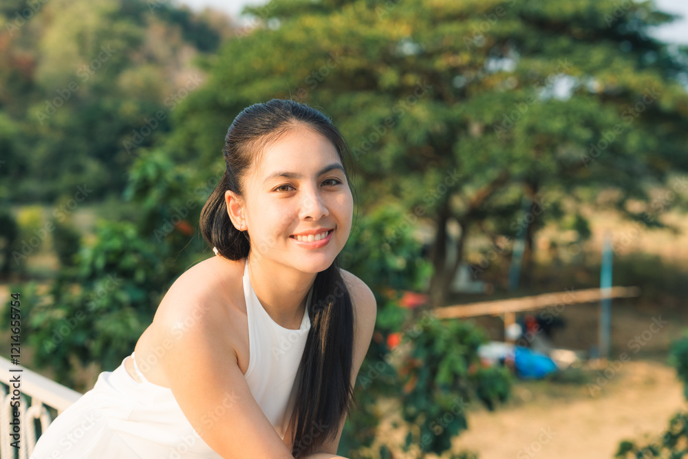 Smiling young asian woman in white dress enjoying a sunny day outdoors Smiling young asian woman in white dress enjoying a sunny day outdoors