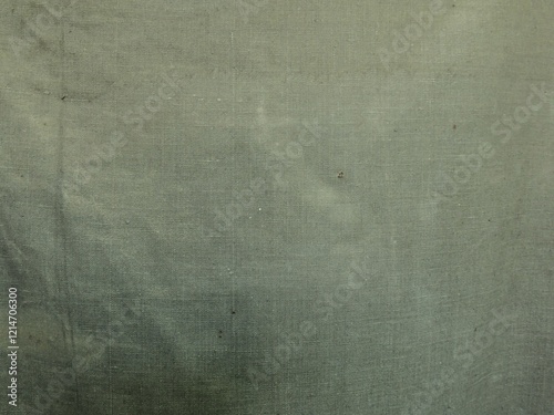 texture of rough tarpaulin fabric dirty green color close-up, fabric background of awning or camouflage macro view, old wrinkled dirty shabby canvas as an empty backdrop