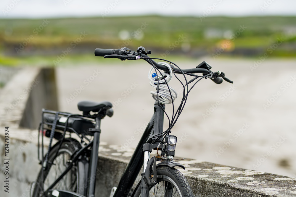 Electric bikes parked on Inishmore, the largest of the Aran Islands in Galway Bay, Ireland. Renting a bicycle is the most popular way to get around Inis Mor. Electric bikes parked on Inishmore, the largest of the Aran Islands in Galway Bay, Ireland. Renting a bicycle is the most popular way to get around Inis Mor.