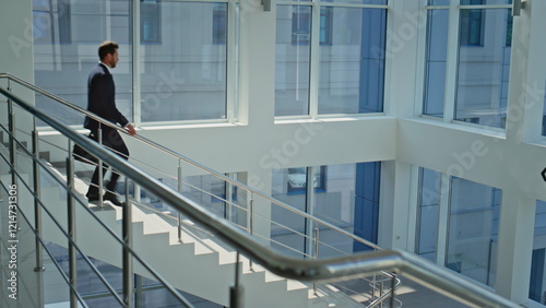 Canvas Print Motivated manager walking downstairs modern sunlit office