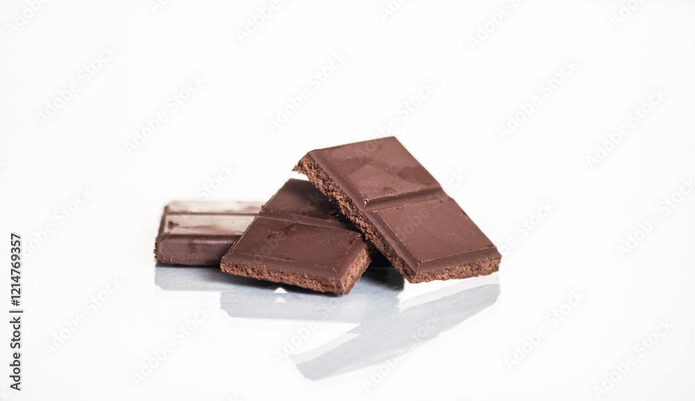 slices of delicious dark chocolate on a light background. slices of delicious dark chocolate on a light background.