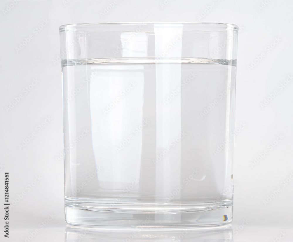 Clear glass filled with water on a plain background Clear glass filled with water on a plain background