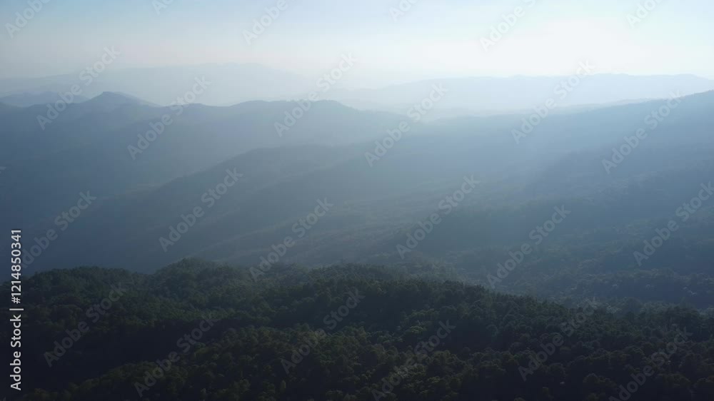 Beautiful sunset in the winter mountains. The setting sun shines down on a serene mountain landscape covered with tropical trees in the evening. Beautiful sunset in the winter mountains. The setting sun shines down on a serene mountain landscape covered with tropical trees in the evening.
