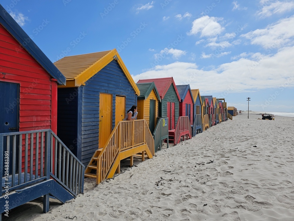 Tourist in vibrant beach huts lining the sandy shores of muizenberg beach in cape town enhance the coastal landscape's charm Tourist in vibrant beach huts lining the sandy shores of muizenberg beach in cape town enhance the coastal landscape's charm