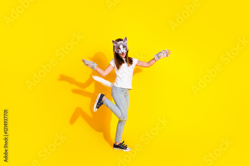 Young girl in cat disguise against vibrant yellow backdrop showcasing playful youthful energy photo