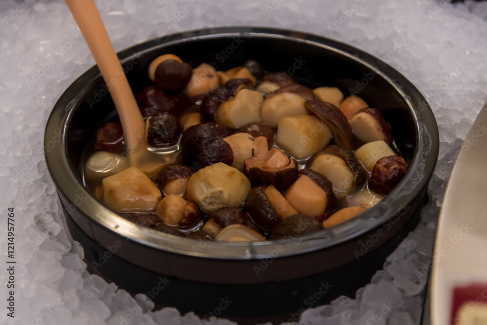 Colorful bowls of gourmet mushrooms are arranged neatly on ice, making a tempting display at a food market event. Copy space. Soft focus. Colorful bowls of gourmet mushrooms are arranged neatly on ice, making a tempting display at a food market event. Copy space. Soft focus.