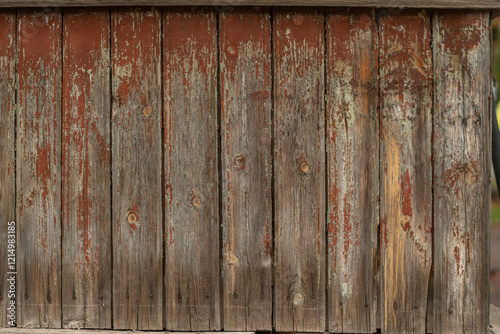 Wall made of an old wooden boards with peeling brown paint.