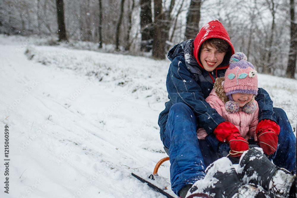 Siblings enjoying a winter day of sledding in a snowy park Siblings enjoying a winter day of sledding in a snowy park