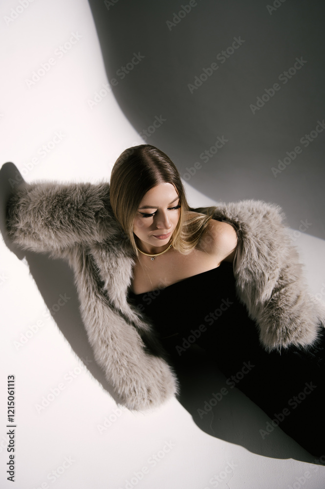 Portrait of a woman in a studio with professional lighting in a smart dress with gloves and a fur coat