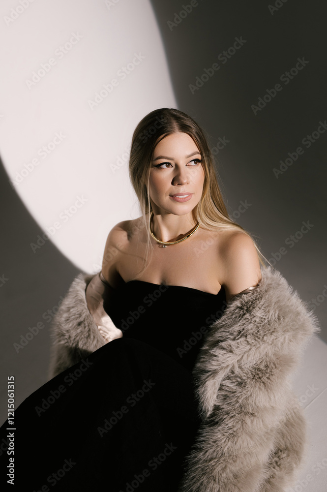 Portrait of a woman in a studio with professional lighting in a smart dress with gloves and a fur coat