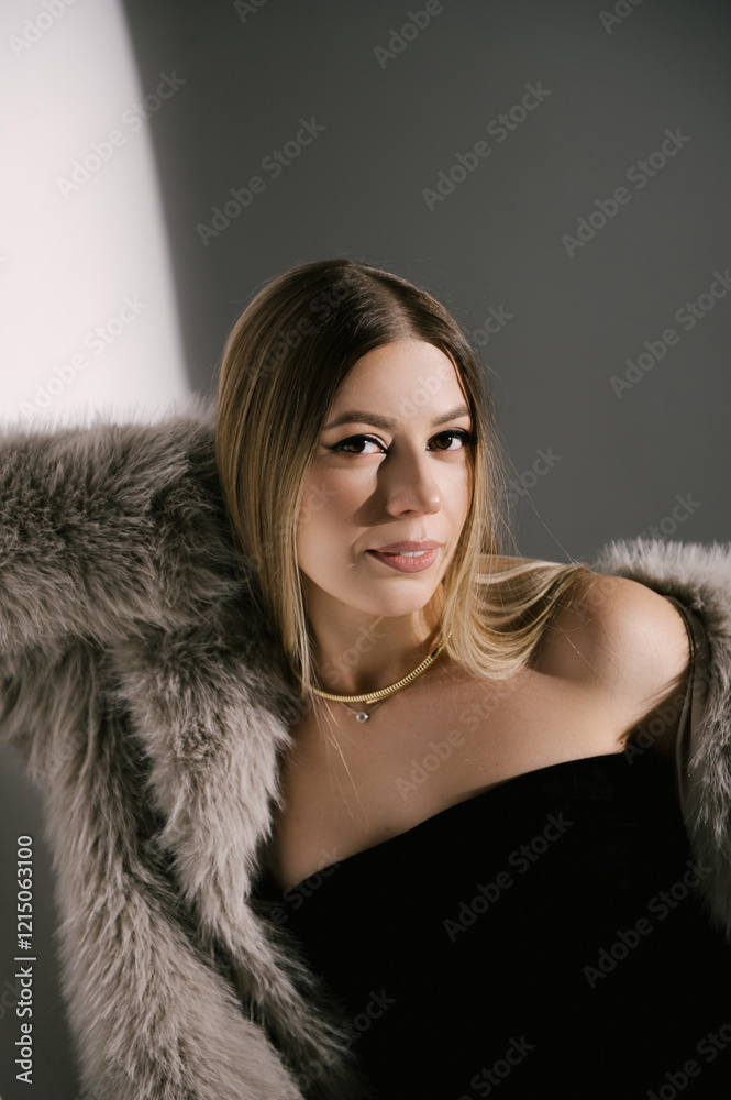 Portrait of a woman in a studio with professional lighting in a smart dress with gloves and a fur coat