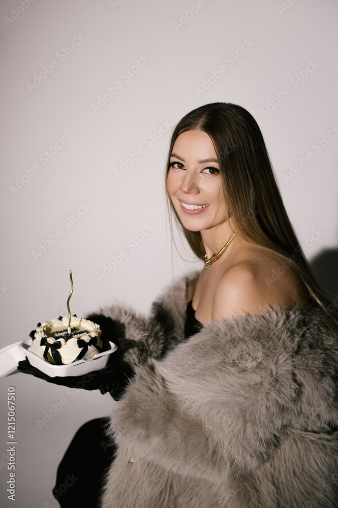 Portrait of a woman in a studio with professional lighting in a smart dress with gloves, in a fur coat with a bento cake on her birthday