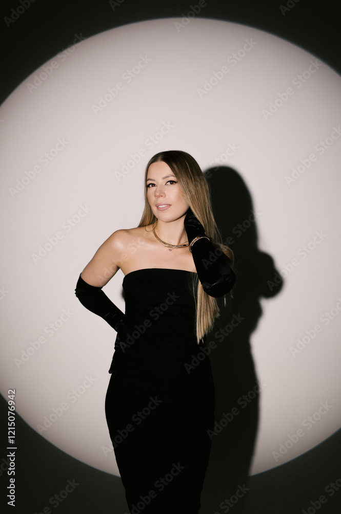 Portrait of a woman in a studio with professional lighting in a smart dress with gloves