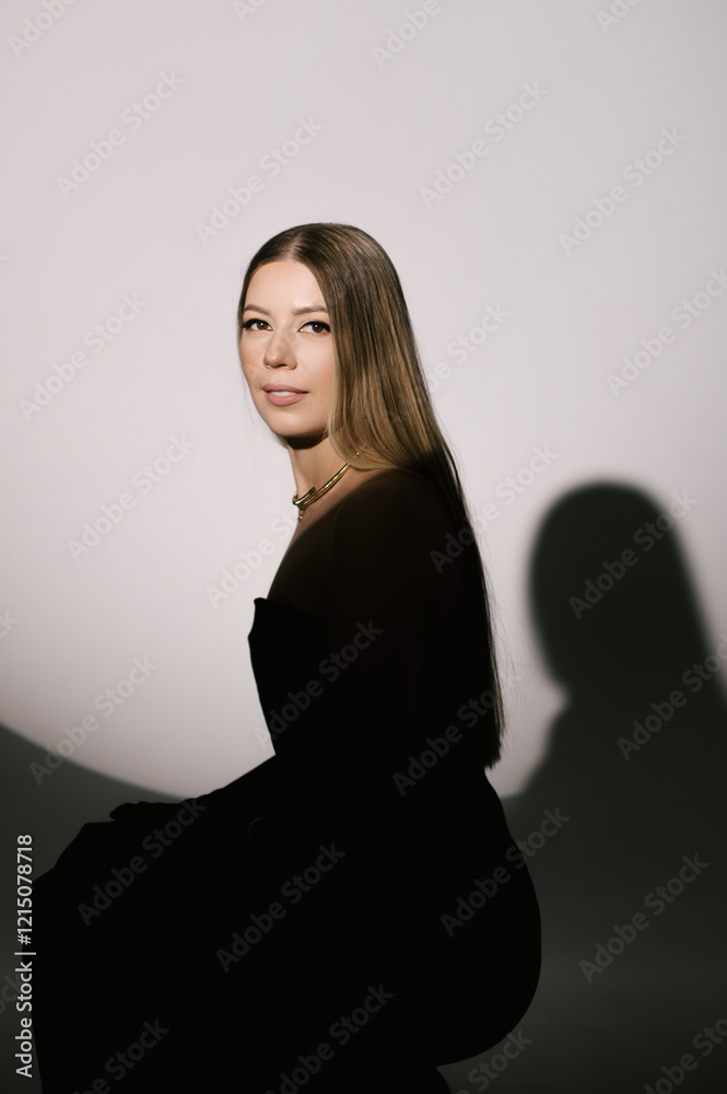 Portrait of a woman in a studio with professional lighting in a smart dress with gloves