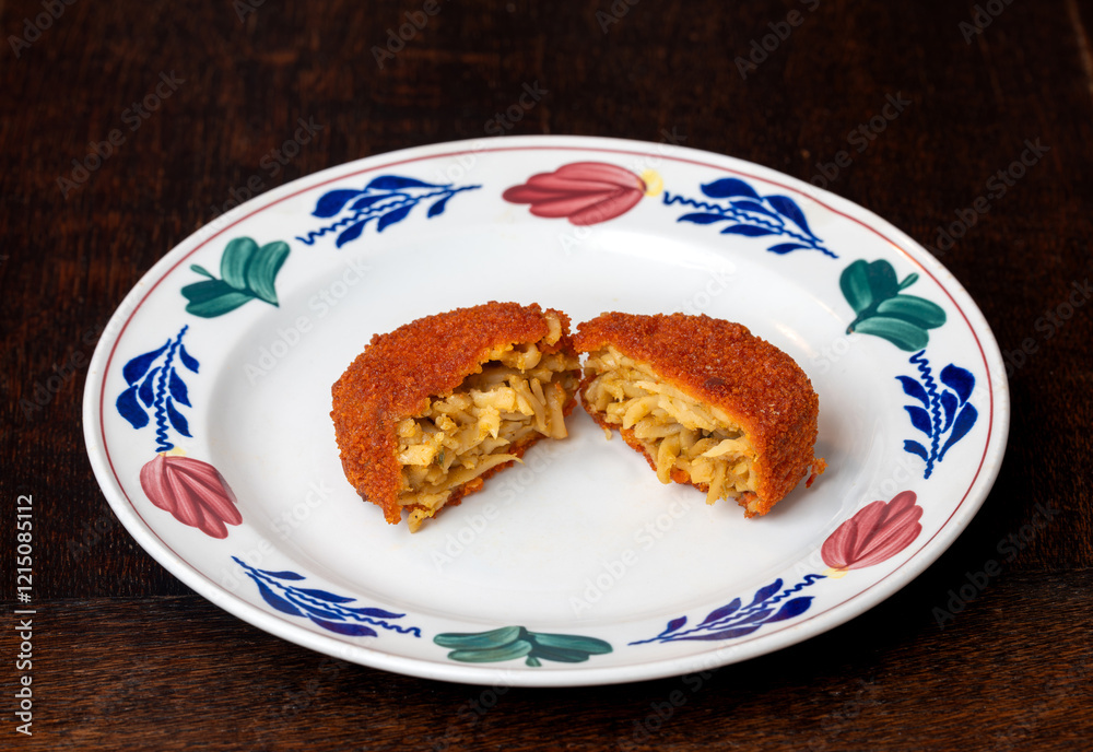 Halved bamischijf on the plate, dutch snack consisting of breaded and deep fried bami noodles Halved bamischijf on the plate, dutch snack consisting of breaded and deep fried bami noodles