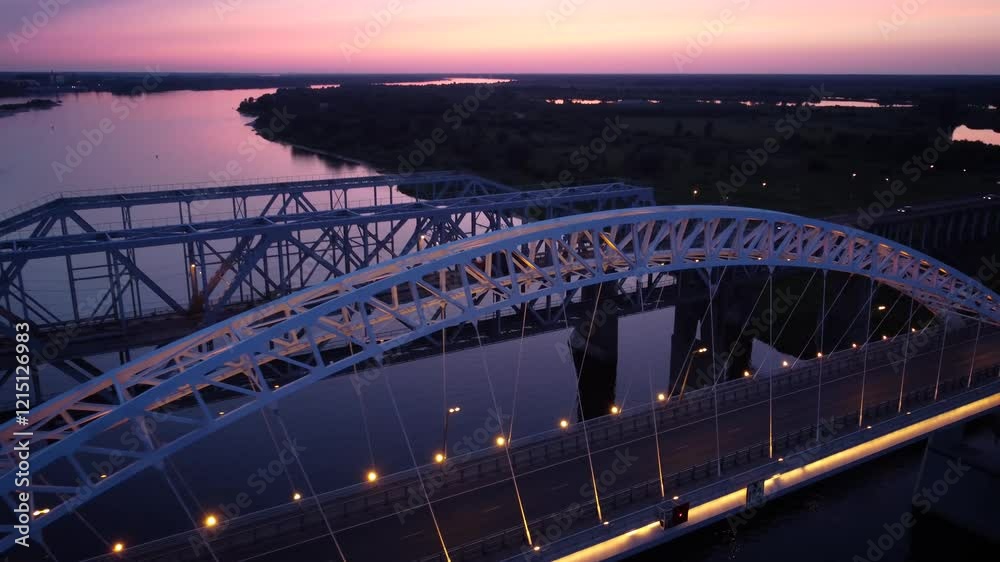 Vertical view from top down. Flying over the road bridge in the late evening. Highway over the river.