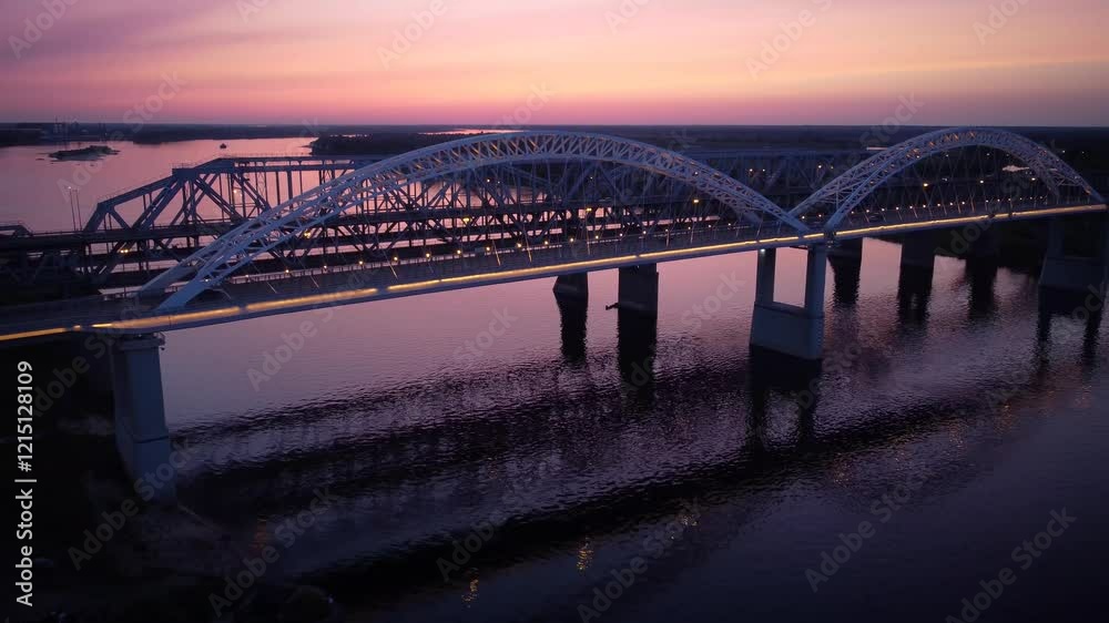 Vertical view from top down. Flying over the road bridge in the late evening. Highway over the river.
