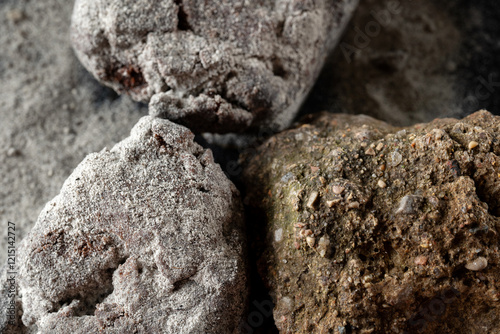 An exquisite and artistic dessert presentation featuring elegant chocolate and fine powdered sugar. Decorated with natural stones. Macro top view