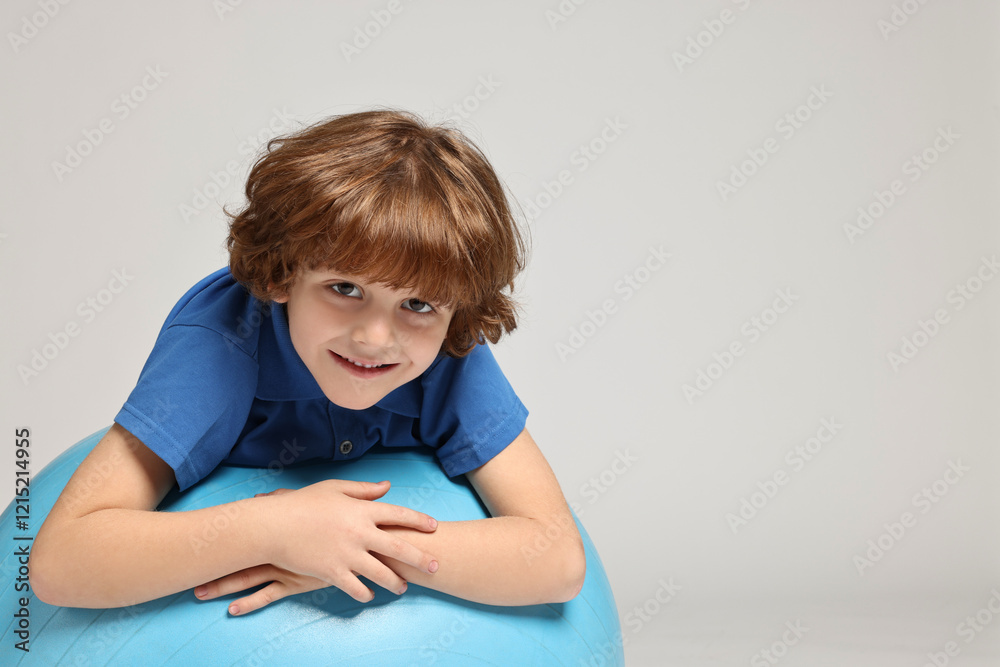 Little boy with fitness ball on light grey background, space for text Little boy with fitness ball on light grey background, space for text