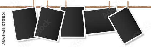 Five blank instant photographs are hanging on a clothesline held by wooden clothespins, creating a nostalgic display of memories yet to be made
