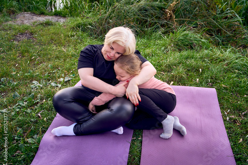 Mother and daughter sharing a comforting hug outdoors in a riverside photo