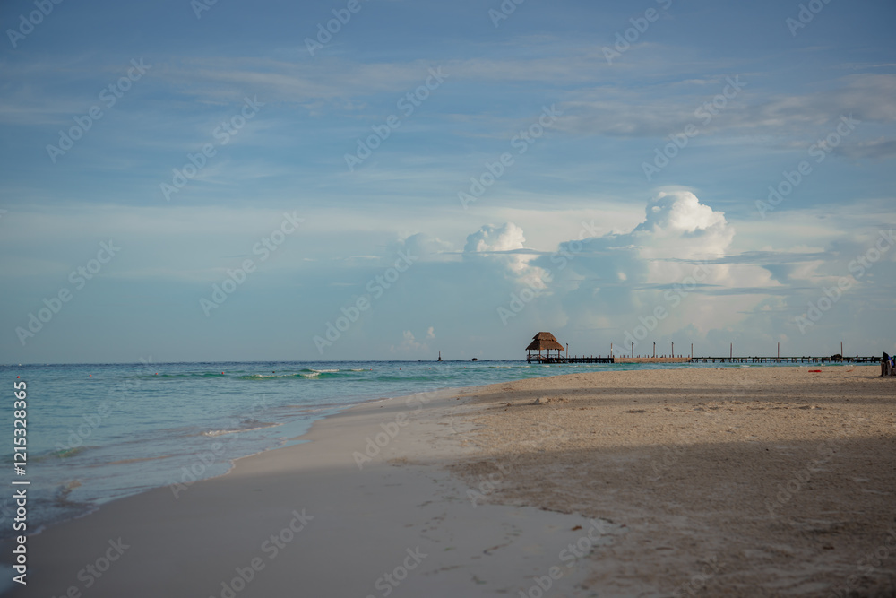 Obraz premium Caribbean Sea beach with azure water and thatched hut on the horizon.
