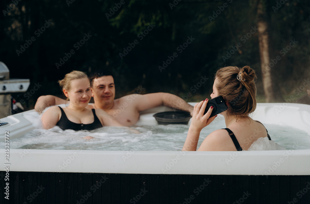 Obraz premium Three friends on a weekend in the countryside relax in a hot smart jacuzzi, enjoying the company and tranquility of the outdoors.