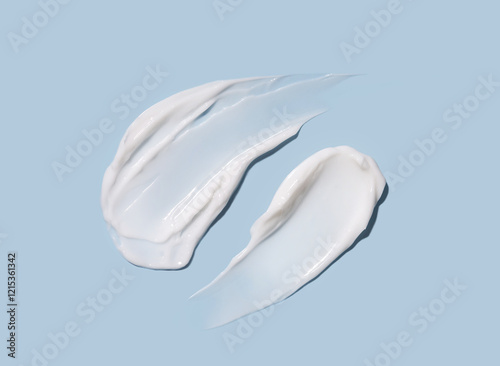 Cosmetic smears of cream texture on pastel blue background. Skin hydration.