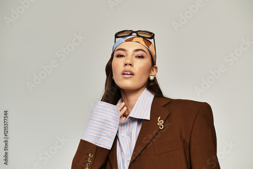 A stunning woman flaunts her fashion with a chic outfit and bold accessories in a modern setting.