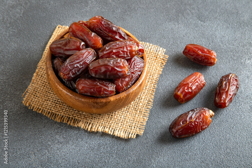 Large size dates fruit in a wooden bowl, top view
 photo