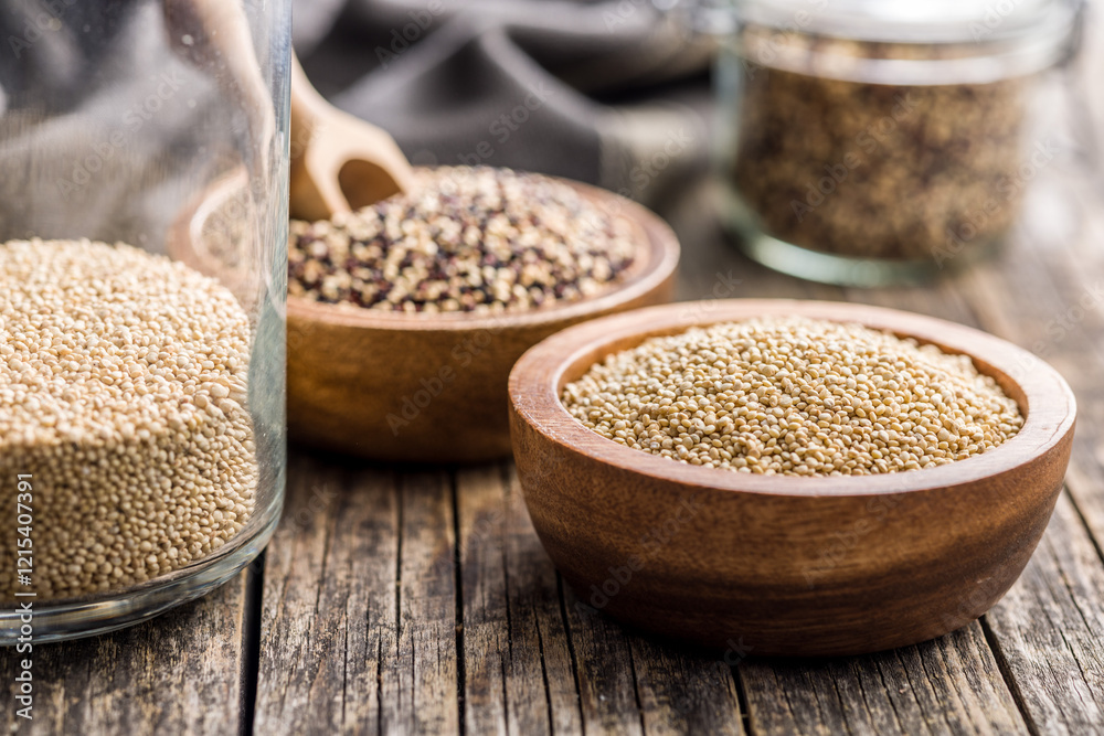 Mixed uncooked quinoa seeds in bowl on wooden table. Mixed uncooked quinoa seeds in bowl on wooden table.