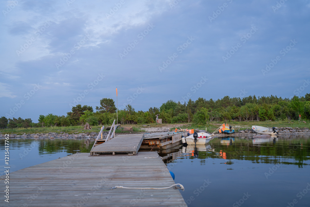 Fototapeta premium Fishing boat pier and boats on the seashore at evening. Fishing boats with net flags by the pier. 