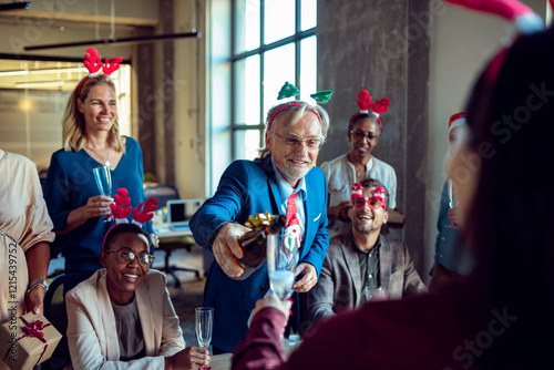 Diverse colleagues having office Christmas party team toasting with champagne photo