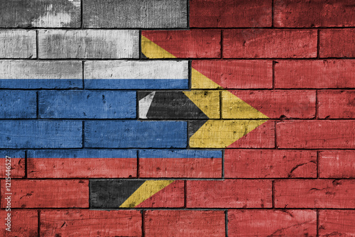 colourful painted big flag of russia and flag of east timor on a massive old brick wall background. concept photo