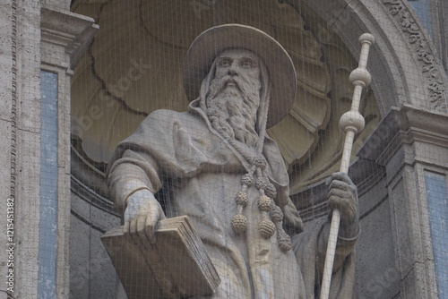 Close up of a historic statue of Saint Jerome, St. Hieronymus, carrying a staff and a Bible at St. Stephen's Basilica in Budapest, Hungary photo