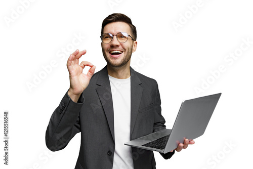 Smiling man in a suit holds a laptop while signaling approval in a bright setting