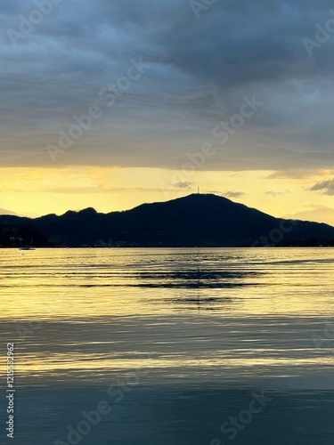 Serene golden sunset over tranquil mountain lake reflection