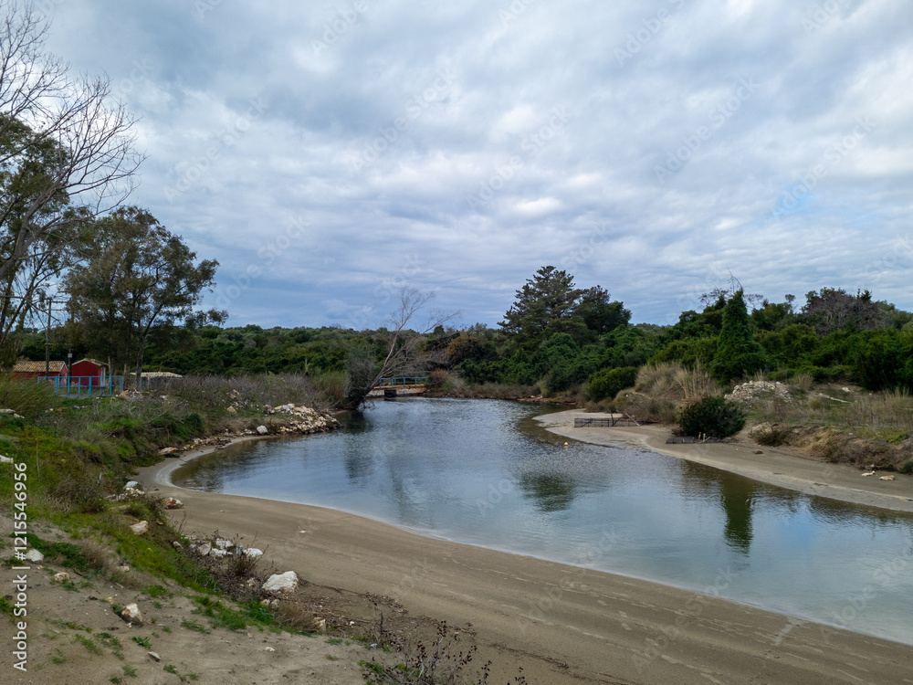 Serene river flowing through a natural landscape under a cloudy sky. Serene river flowing through a natural landscape under a cloudy sky.