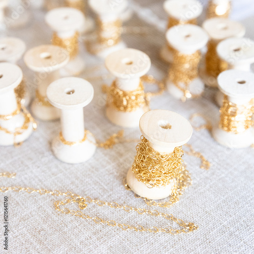 Jewelry chains on wooden spools, gold