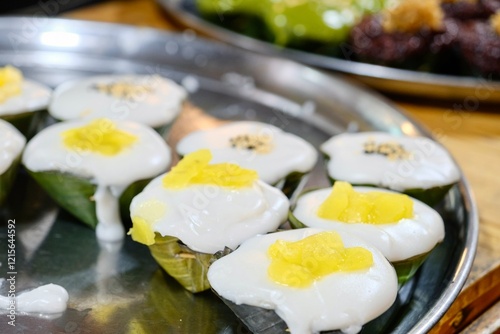 Khanom Tako (a Thai dessert made from glutinous rice flour and coconut cream, served in a pandan leaf or banana leaf casing) at Khlong Lat Mayom, a floating market in Taling Chan, Bangkok, Thailand photo